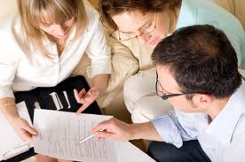 group of real estate lawyers going through an agreement of purchase and sale with a buyer or seller.