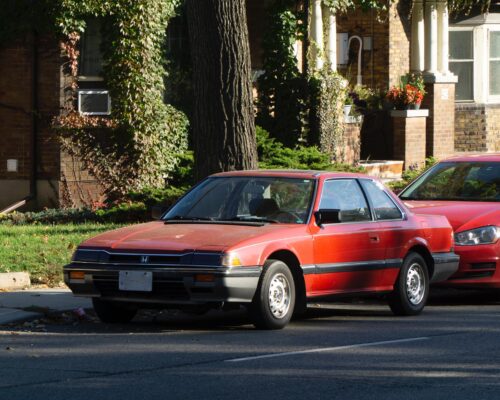 A red car parked on Bloor St. in Toronto Ontario.